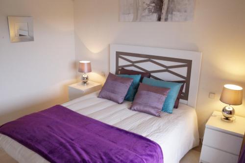 Bahia de Casaresにある2143-Lovely 2 bedrooms newly furnishedのベッドルーム1室(紫と青の枕が備わるベッド1台付)