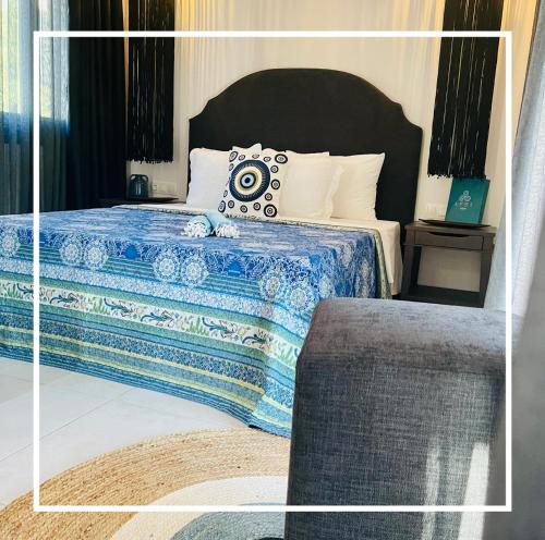 1 dormitorio con 1 cama con manta azul y blanca en Epos Villas & Luxury Studios en Paliouri