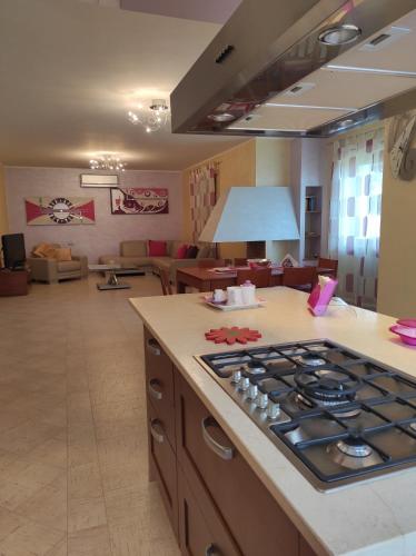 a kitchen with a stove and a living room at Villa Pina in Ferrazzano