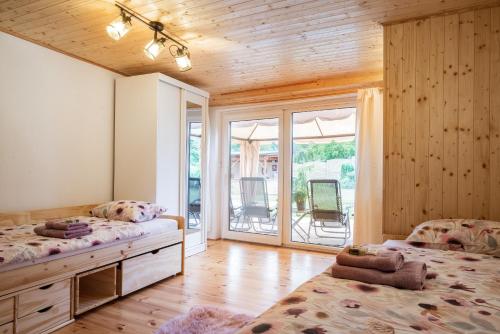 a bedroom with two beds and a large window at Statek U Dubu in Svojetín