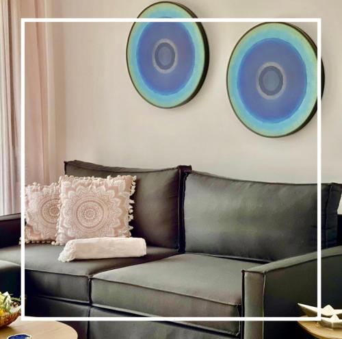 sala de estar con sofá de cuero y 2 placas en la pared en Epos Villas & Luxury Studios en Paliouri