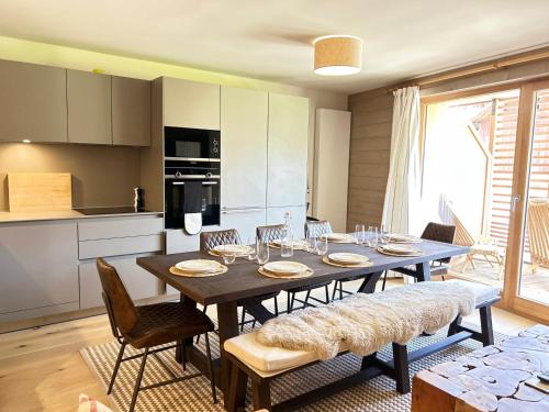 une salle à manger avec une table et des chaises dans une cuisine dans l'établissement Appartement de Standing au Centre des Gets - 8 Couchages, Terrasse, Garage, Proche Pistes - FR-1-623-325, aux Gets