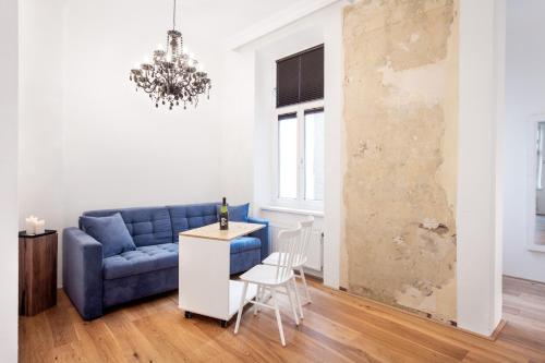 a living room with a blue couch and a table at Grand Hôtel Wiesler - Centre of Graz in Graz