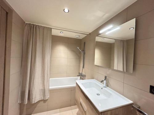une salle de bain avec un lavabo, un miroir et une baignoire dans l'établissement Appartement de Standing au Centre des Gets - 8 Couchages, Terrasse, Garage, Proche Pistes - FR-1-623-325, aux Gets