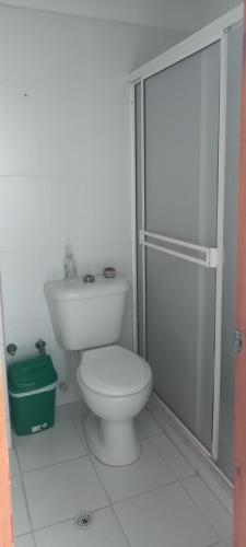 uma casa de banho branca com um WC e um chuveiro em Reservas La Bonanza S.A.S em Santa Marta
