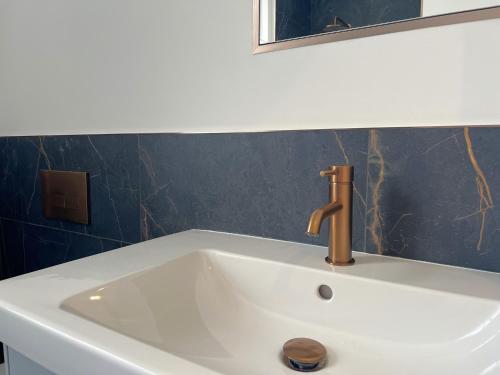 un lavabo blanco con grifo y espejo en Black Horse Apartments, en Knaresborough