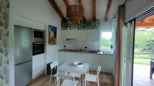 una cucina con tavolo e sedie bianchi di La Flor de Agua a Torielló