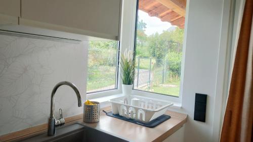 eine Küchentheke mit einem Waschbecken und einem Fenster in der Unterkunft La Flor de Agua 