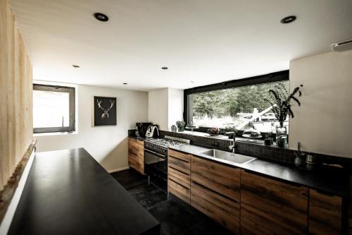 a kitchen with a sink and a large window at La Loge de la Dolarde - Chambre Nord-Est in Prémanon