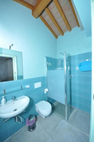 uma casa de banho azul com um WC e um lavatório em Casalotto Francescano em Mengara