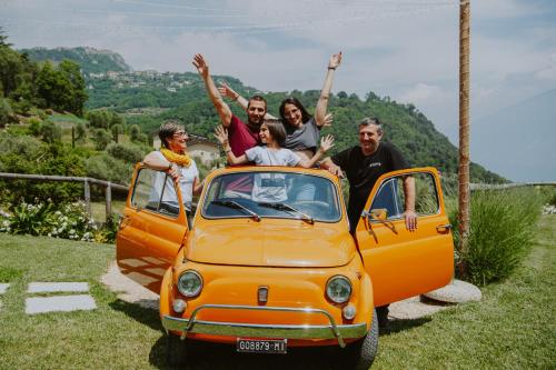 a group of people sitting on the back of an orange car at Stella D'Oro - Hotel & Apartments in Tremosine Sul Garda