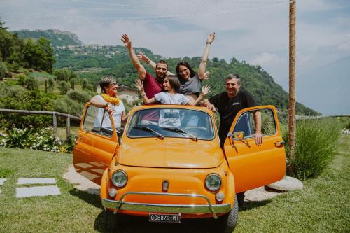 een groep mensen die achterop een oranje auto zitten bij Stella D'Oro - Hotel & Apartments in Tremosine Sul Garda