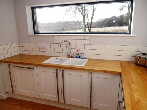 a kitchen with a sink and a window at Laundry Cottage in Aberlour