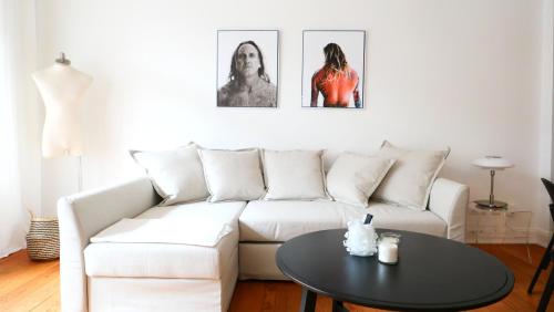 a living room with a white couch and a table at Elbperle! Zentrales Apartment an der Elbe in Hamburg