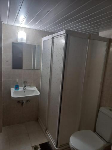 een badkamer met een douche, een toilet en een wastafel bij Arma pansiyon in Antalya