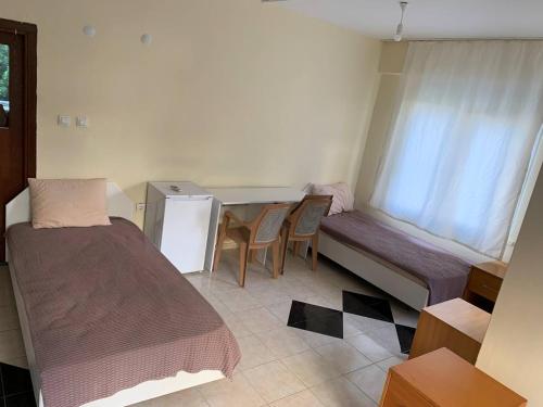 een kleine kamer met een bed, een bureau en een tafel bij Arma pansiyon in Antalya