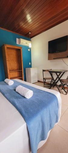 a bedroom with a bed with a blue blanket at Pousada Paraty Graziela in Paraty