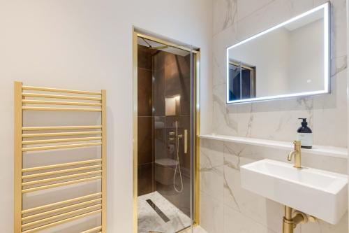 a bathroom with a shower and a sink and a mirror at Dragon Suites Luxury Serviced Apartments at Walker Street in Edinburgh
