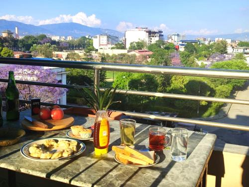 una mesa con comida y bebida en el balcón en Panoramic apartment in peaceful location of Thamel, en Katmandú