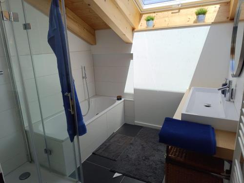 a small bathroom with a shower and a sink at Apartment unterm Dach mit kleinem Seeblick in Münsing am Starnberger See