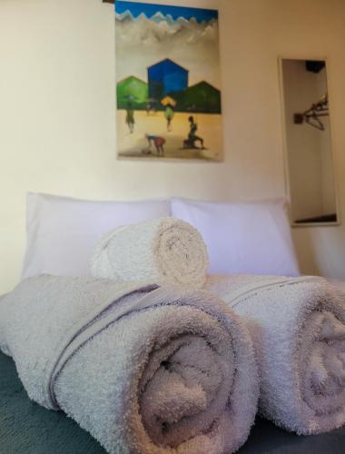 a pile of towels on top of a bed at Pousada Raiz Forte in Caraíva