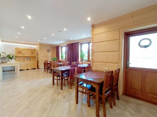 a dining room with wooden tables and chairs at POKOJE GOŚCINNE U ZOŚKI in Murzasichle