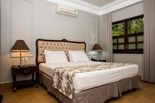 a bedroom with a large bed and a window at Lagos de Jurema Termas Resort in Iretama