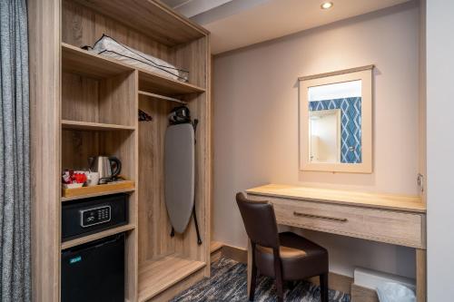 a room with a desk with a chair and a mirror at Rochestown Lodge Hotel in Dun Laoghaire
