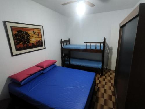 una camera con un letto blu e una culla di Apartamento Beira Mar - Enseada - Guarujá - 150 metros da praia a Guarujá