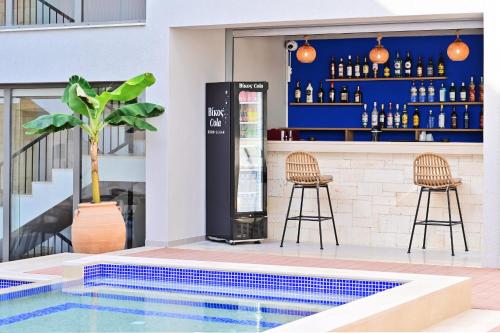 un bar con dos taburetes y una piscina en Maltepe Luxury Accommodation by Travel Pro Services, en Kallithea Halkidikis