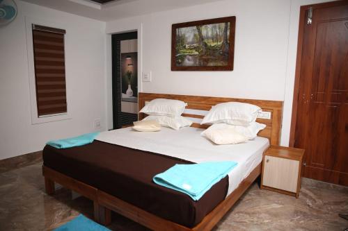 1 dormitorio con 1 cama con sábanas y almohadas blancas en Bhuvanam homestay en Kalpatta