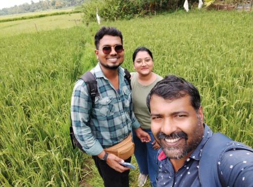 a group of three people standing in a field at Bhuvanam homestay in Kalpetta