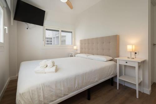 1 dormitorio con 1 cama con 2 toallas en Apartoyou - Enamorados, en El Puerto de Santa María