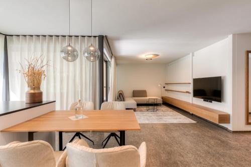 a living room with a table and a television at Boutique Hotel AMARIL in Castelbello-ciardes