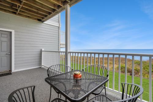 a table and chairs on a balcony with the ocean at The Cliffside Resort Condominiums in Greenport
