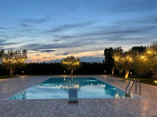 una piscina por la noche con las luces encendidas en Villa Nascente, en Bitetto