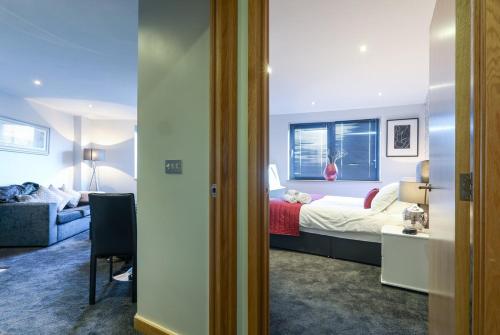 a bedroom with a bed and a room with a couch at Victoria Mills Apartment Shipley in Shipley