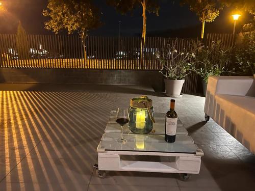 a table with a bottle of wine and two glasses at Domus Aurea in Palamós