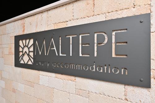 una señal en el lateral de un edificio de ladrillo en Maltepe Luxury Accommodation by Travel Pro Services, en Kallithea Halkidikis