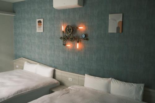 a bedroom with two beds and a clock on the wall at 埔里柴居民宿 in Puli