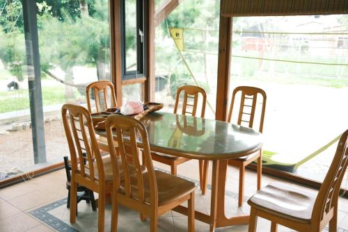 埔里鎮的住宿－埔里柴居民宿，一间设有玻璃桌和椅子的用餐室