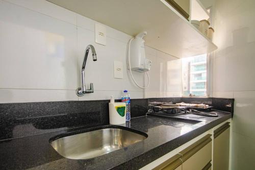 a kitchen with a sink and a stove at Apartamento Incrível in Salvador