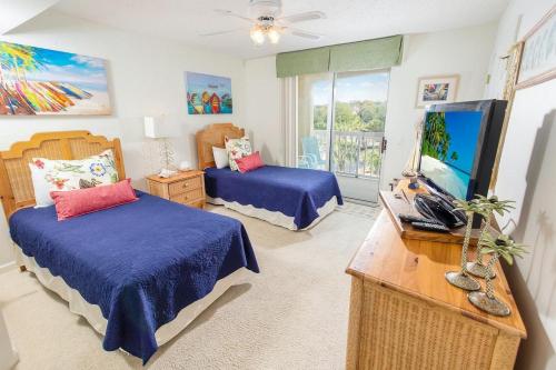 帕瓦雷斯岛Oceanfront Paradise: 3 Bdrm Condo, Pawleys Island的一间卧室，配有两张床和一台平板电视
