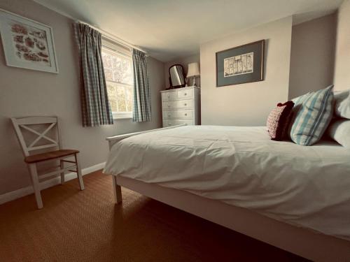 - une chambre avec un lit, une commode et une fenêtre dans l'établissement Pass the Keys Scallop Cottage Oasis of Calm, à Rye
