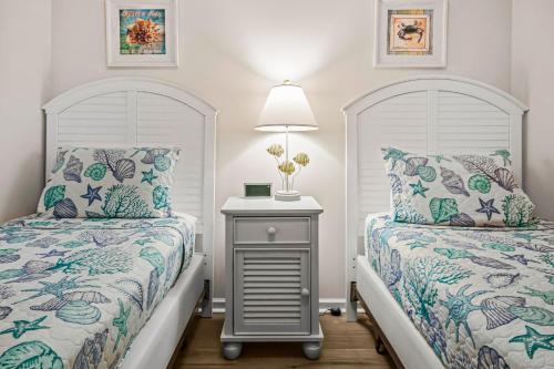 a bedroom with two beds and a table with a lamp at Yellow Daisy & Beach Escape in North Myrtle Beach