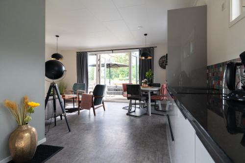 a kitchen and dining room with a table and chairs at Recreatiepark Maas en Bos in Wellerlooi
