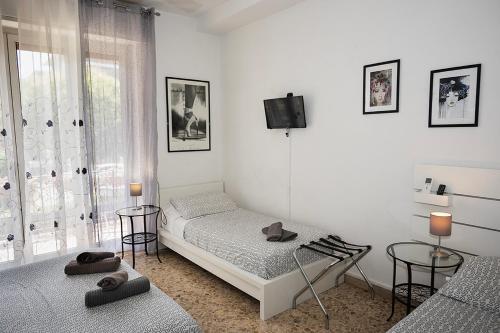 a bedroom with two beds and a tv on the wall at B&B Pisaland in Pisa