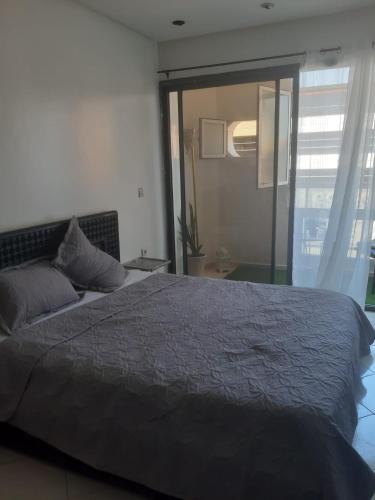 1 dormitorio con cama grande y ventana grande en APPARTEMENT Hana Majorelle en Marrakech