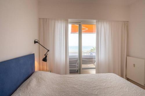 een slaapkamer met een bed en uitzicht op de oceaan bij Luxury flat on the Cote d'Azur in Villeneuve-Loubet