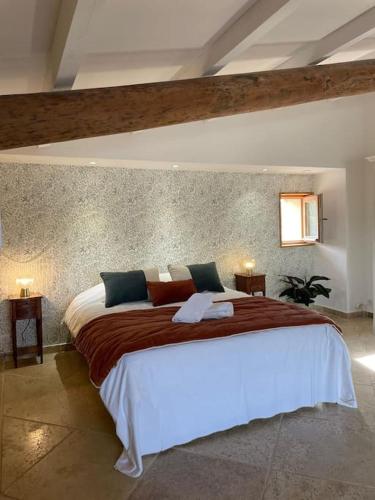 une chambre avec un grand lit dans une pièce dans l'établissement Bastide provençale au cœur de la Provence Verte, à Rians